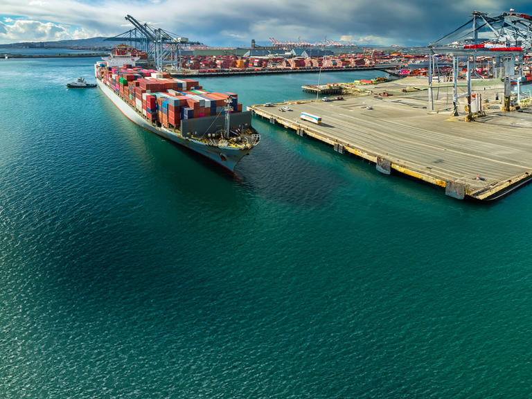 A large container ship docks at a shipping port
